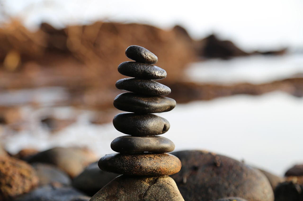 Stacked stones beside the water, representing balance and meditation